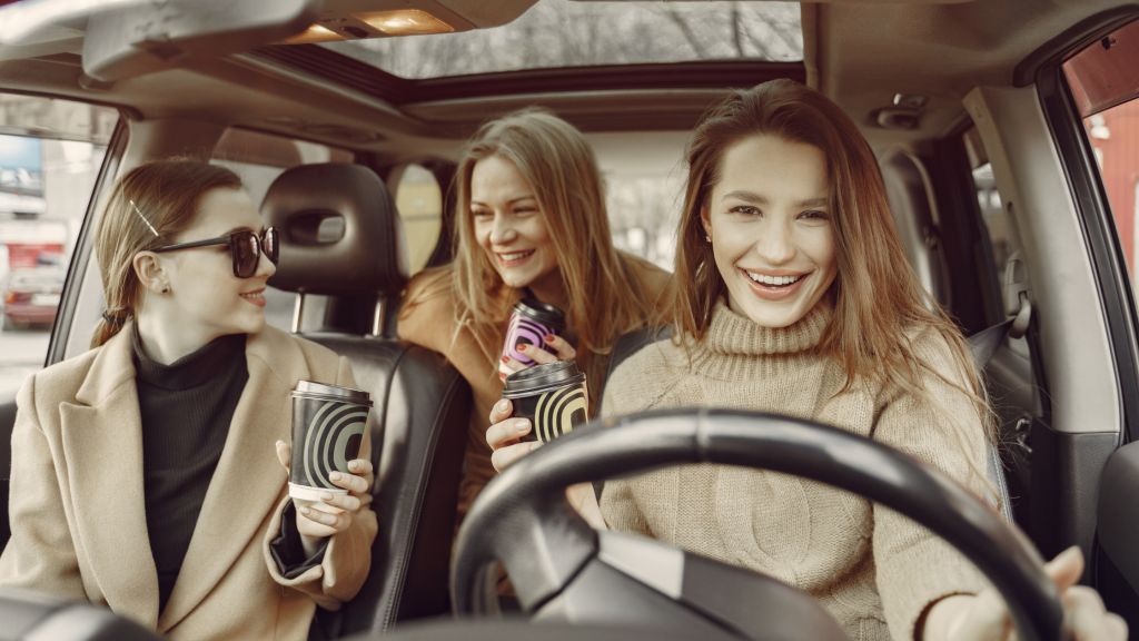 Three women laughing and enjoying a road trip, exploring the world together.